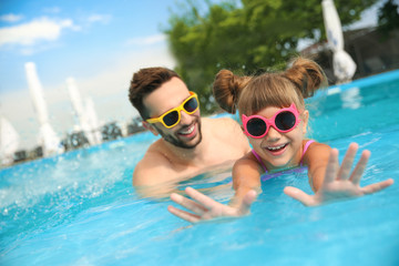 Canvas Print - Father and daughter having fun in swimming pool. Family vacation