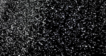 Wall Mural - cloud of shiny snowflakes floating in the air. the shot was taken while the snowflakes were on an is
