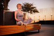 © Naz - Middle age caucasian woman practicing yoga outdoors in city during beautiful sunset at summer.