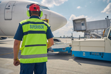 Man performing a visual inspection of the landed airplane