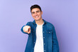 © luismolinero - Teenager caucasian  handsome man isolated on purple background points finger at you with a confident expression