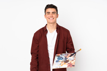 Wall Mural - Teenager artist man holding a palette isolated on white background smiling a lot