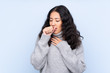 © luismolinero - Spanish Chinese woman over isolated blue background is suffering with cough and feeling bad