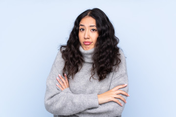 Sticker - Spanish Chinese woman over isolated blue background making doubts gesture while lifting the shoulders