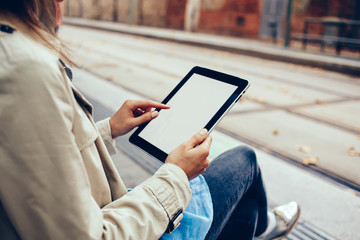 Cropped view of female person hands holding digital touch pad device with blank screen area for advertising text message.Young woman touching with finger on mock up display of modern tablet with 4G