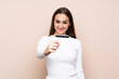 © luismolinero - Young woman over isolated background holding a credit card