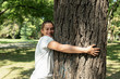 © Srdjan - Beautiful smiling young positive and happy environmentalist girl hugging the big tree in the park love the nature and want to protect environment environmental concept save the forest