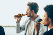 © master1305 - Group of friends celebrating, resting, having fun and party in summer day. Young men drinking beer, talking, laughting. Look happy and cheerful. Festive time, holiday, summertime, unity and friendship