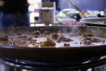 Closeup shot of the preparation of a chicken paella on the gas