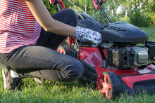 Woman Checking Lawn Mower Oil