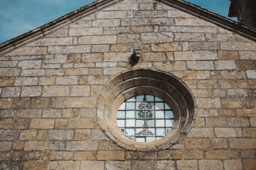 Wall Mural - Closeup shot of a circle-shaped window on an ancient building in Portugal