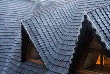 Shingles On The Roof. Wooden Roof, Shingled Roof. Wooden Tile. Roof Of Complex Construction With Dormer Windows