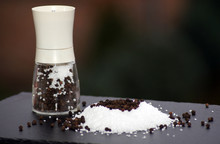 Closeup Shot Of Coarse Salt And Pepper Grains On A Smooth Surface