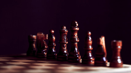 Wall Mural - Wooden chess in a contrasting light. A game of chess, an intellectual competition,