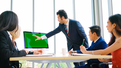 Wall Mural - Business people in the conference room with green screen chroma key TV or computer on the office table. Diverse group of businessman and businesswoman in meeting on video conference call .