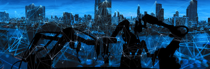 Silhouette of modern automation robot arms with Ai assistant technology network concept and metropolis city building background.