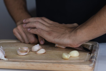 Sticker - Closeup shot of a young man cutting garlic