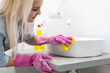 © Angelov - Housework and domestic lifestyle: woman doing chores in bathroom at home, cleaning wash basin and tap with spray detergent