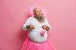 © wayhome.studio  - Funny plump male party organizer dresses in fairy costume, comes in kindergarten to entertain preschool children, poses with fluffy magic wand, looks thoughtfully aside, celebrates carnival.