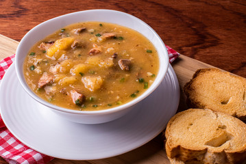 .Cassava broth. Creamy broth made with cassava, sausage, bacon and meat. .Accompanied by toast Top view Top view