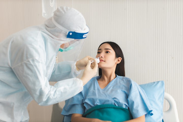 Wall Mural - Medicine and health care concept.  Asian doctor is taking care patient woman in hospital.doctor or nurse wear protection mask checking and takecare infection people from covid-19 .