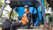 © Ron - Mechanical engineer with face mask using forklift in a factory. Factory in new normal during Coronavirus or COVID-19 outbreak. A worker in safety jacket and face mask