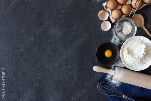 Fotografía Ingredients and tools for dough preparation on black background top view