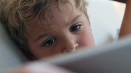 Wall Mural - Kid face staring at screen close-up. Hypnotized child watching media online