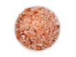 Himalayan pink rock salt in bowl isolated on white background, top view