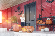 Little Boy Near Red House With Carved Pumpkins