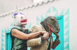 © Alessandro Biascioli - Crazy senior couple wearing unicorn and t-rex mask while dancing outdoor - Mature trendy people having fun celebrating carnival time - Absurd concept of masquerade funny holidays