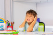 Screaming sad boy with autistic disorder cover ears and grin during development therapy class lesson