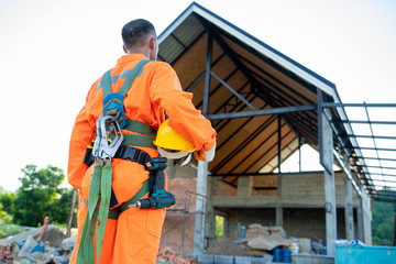 Poster - Construction worker wearing safety harness and safety line working at high place work at building site,Concept of residential building under construction.