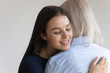 I am so happy to have you, mom. Adult woman hugging her elderly aged mother with care and tender gently touching her shoulder with chin, loving grown-up daughter holding on tight to her senior mom