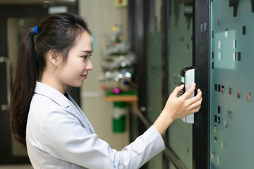 Woman scanning fingerprint and access control for enter security system in a office building