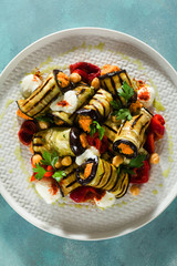 Wall Mural - grilled eggplant wrap with red bell pepper hummus and spicy yogurt on the table. delicious vegan recipe