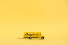 Back To School Concept. Traditional Yellow School Bus On Yellow Background. Transfer To School. Yellow Toy Model School Bus.