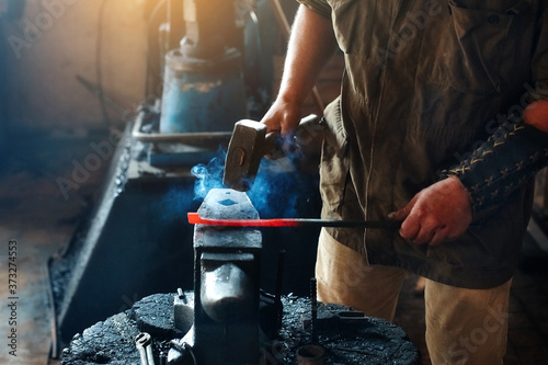 Blacksmith working metal with hammer on the anvil in the forge Tableau sur Toile