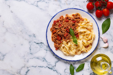 Wall Mural - Traditional italian pasta bolognese on a white plate on a marble background