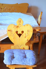 Vintage style carved wooden chair with striped cushion on traditional vintage wooden interior background