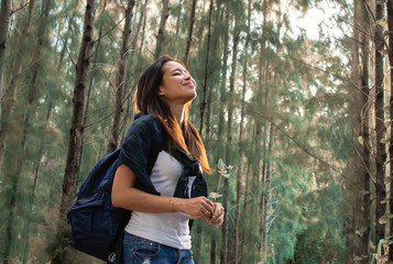 Asian woman traveling and camping in forest with happiness