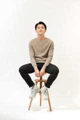 Wall Mural - Full body portrait of handsome young Southeast Asian man sitting on high chair,