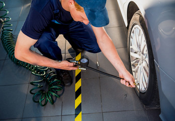 Wall Mural - Professional car mechanic working with in auto repair service. Repair of wheels