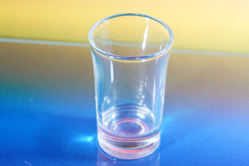 Sticker - Small glass with on the table on a colorful background