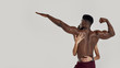 © Svitlana - Sportive mixed race woman embracing, touching muscular african american bodybuilder back while posing together isolated over grey background. Sports, workout, bodybuilding concept