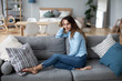 © BestForYou - Relaxed smiling woman sitting on sofa at home.