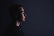 © Валентина Баранова - Portrait of an emotional handsome young man, on a black background in the studio, who stands in a brooding pose. Expression of emotions and feelings