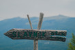 © Anze - Wooden signboard with writing Slavnik, the name of the hill in Slovenian coastline, with the same hill being visible in the background.