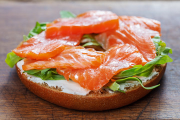 Poster - bagel sandwich with salmon on wooden background