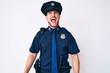 © Krakenimages.com - Young caucasian man wearing police uniform angry and mad screaming frustrated and furious, shouting with anger. rage and aggressive concept.
